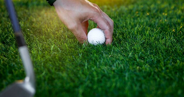 La mano del golfista sostiene la pelota de golf cerca de la hierba en un hermoso paisaje borroso de fondo verde Concepto de deporte internacional que se basa en habilidades de precisión para la relajación de la saludx9