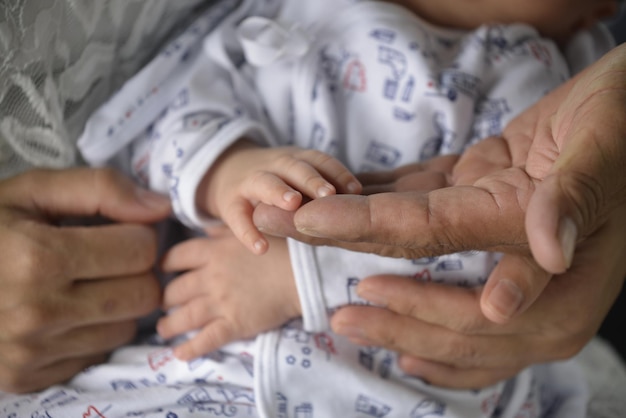 Mano grande de madre vs mano pequeña de bebé Toque de amor