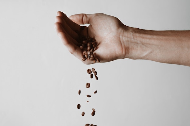mano con granos de cafe