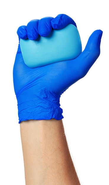 Mano en un guante azul con jabón, cerrar