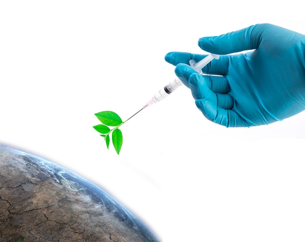Foto la mano en un guante azul sosteniendo una jeringa inyecta la planta al mundo seguro el concepto del mundo los elementos de esta imagen proporcionados por la nasa