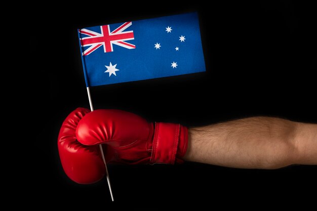 Mano en guante de boxeo sostiene la bandera australiana