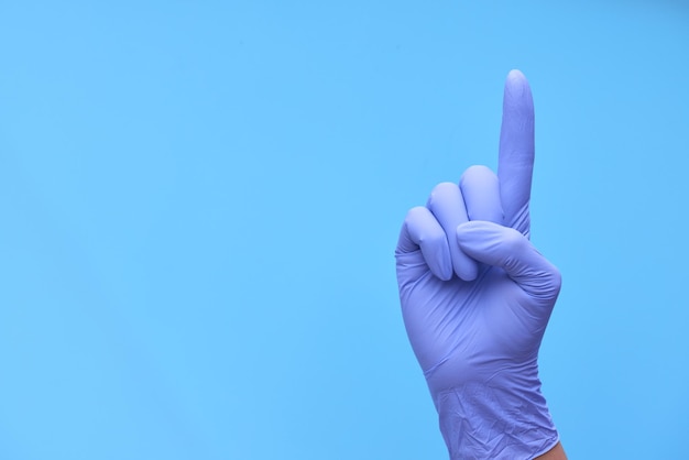 Una mano con guantes azules médicos muestra una cuenta atrás del tiempo o el número de medicamentos