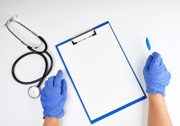 Foto mano en guantes estériles azules y estetoscopio médico.