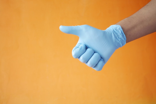 Foto mano en guantes médicos mostrando un pulgar hacia arriba