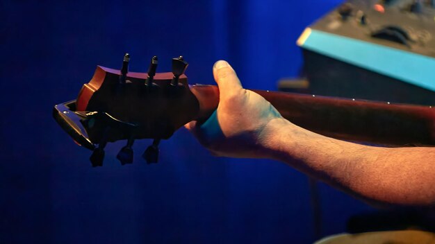 Foto la mano de los guitarristas en el cuello de una guitarra