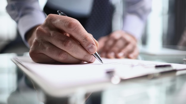 La mano hace notas en un primer plano de un cuaderno de papel