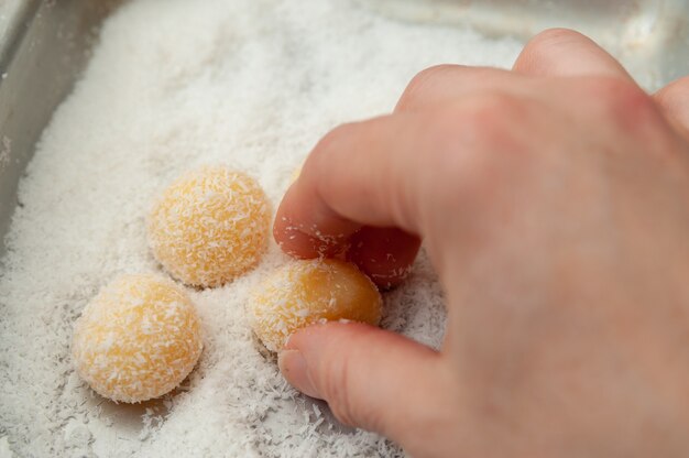 Mano haciendo Beijinho de Coco un dulce tradicional brasileño