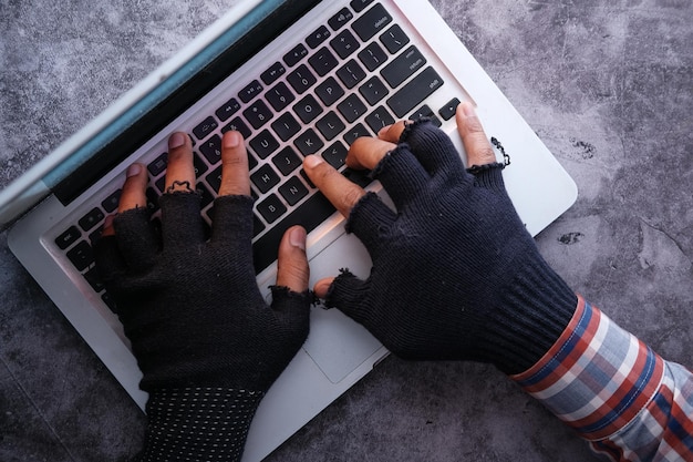 La mano del hacker apunta con el dedo a la pantalla del portátil