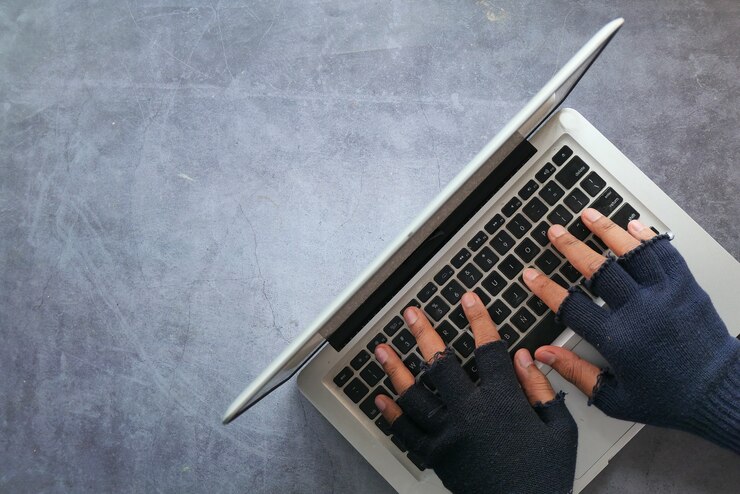 Foto mano de hacker robando datos de la computadora portátil de arriba hacia abajo.