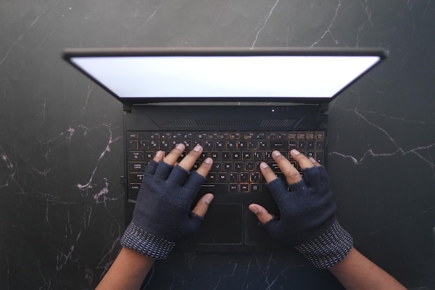 Mano de hacker robando datos de la computadora portátil de arriba hacia abajo