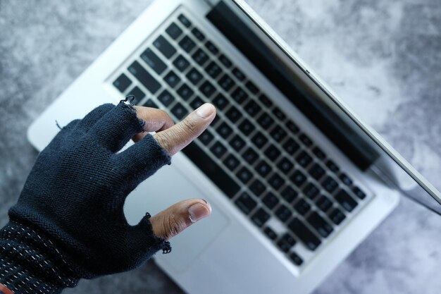 La mano del hacker señalando con el dedo la pantalla del portátil