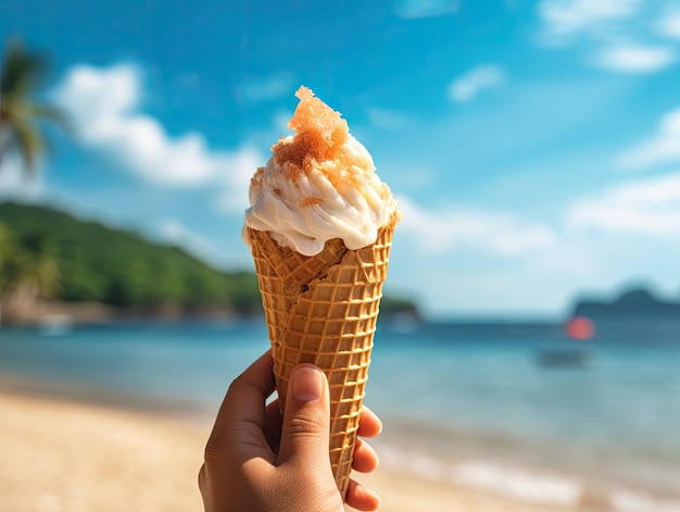 Mano con helado en un cono y playa tropical borrosa en el fondo