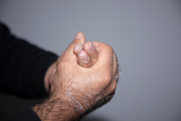 Mano de un hombre aplicando loción crema en los brazos para proteger
