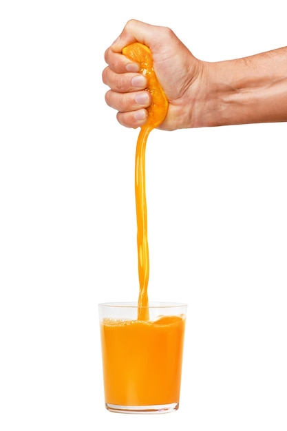 La mano de un hombre aprieta una naranja madura en un vaso Un hombre sostiene y exprime una naranja El jugo de naranja se vierte Aislado en un fondo blanco