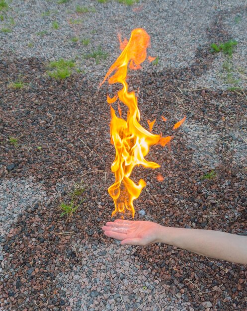 Foto la mano de un hombre arde con una llama brillante.