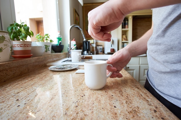 Mano del hombre blanco preparando té con bolsa de té