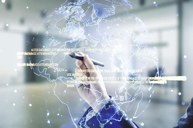 Mano de hombre con bolígrafo trabajando con concepto abstracto de codificación virtual y mapa mundial en fondo de oficina borroso Multiexposición