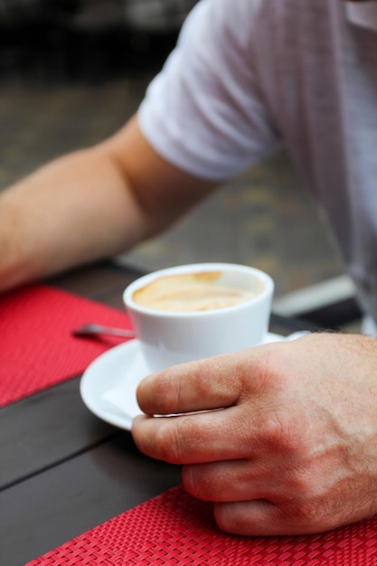 La mano del hombre con el café