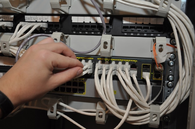 La mano de un hombre conecta el equipo para una conexión a la red de Internet.