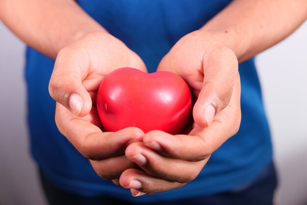 Foto mano de hombre con corazón sobre fondo blanco. de cerca.