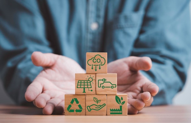 Foto la mano del hombre da el apilamiento de co2 reduciendo el icono de la fábrica verde de reciclaje para reducir la huella de carbono de co2 y el crédito de carbono para limitar el calentamiento global del cambio climático concepto de economía verde circular bio