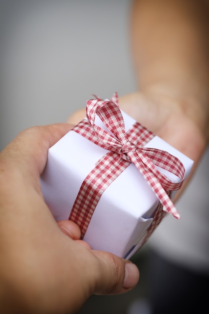 Mano del hombre dando una caja de regalo