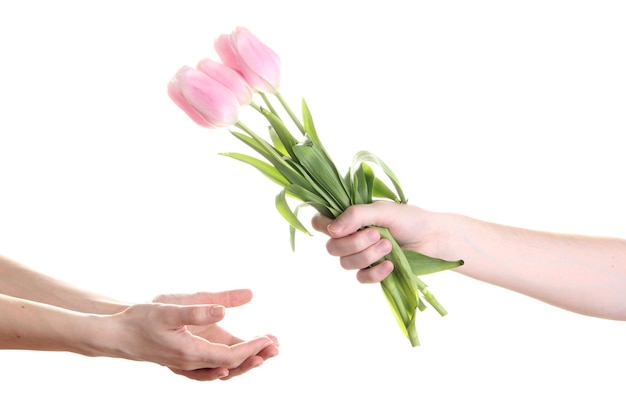 La mano del hombre dando la mano de la mujer un ramo de flores con tulipanes, aislado en blanco