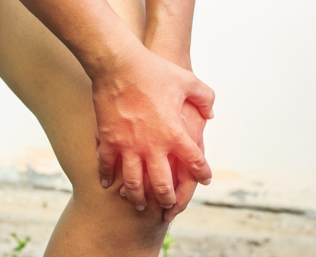 mano del hombre es atrapar la rodilla para Pull up sobre fondo blanco