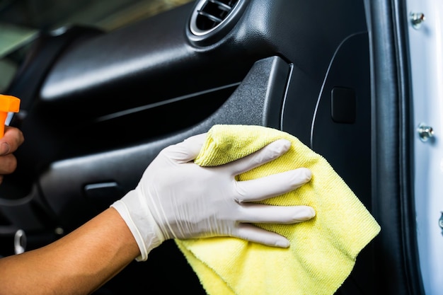 La mano del hombre está limpiando el auto en el garaje