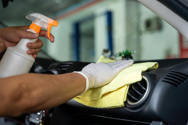 La mano del hombre está limpiando el auto en el garaje