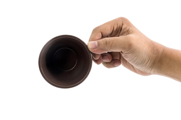 La mano del hombre está vertiendo la taza de café de cerámica aislada