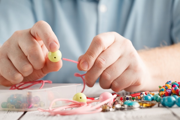 Mano de hombre haciendo aretes de arcilla polimérica.