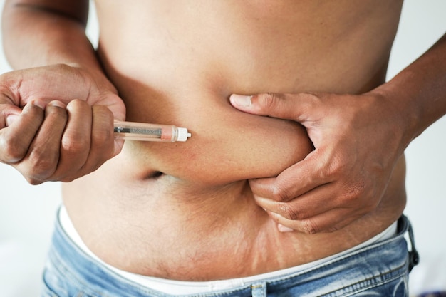 Mano de hombre joven con pluma de insulina cerrar