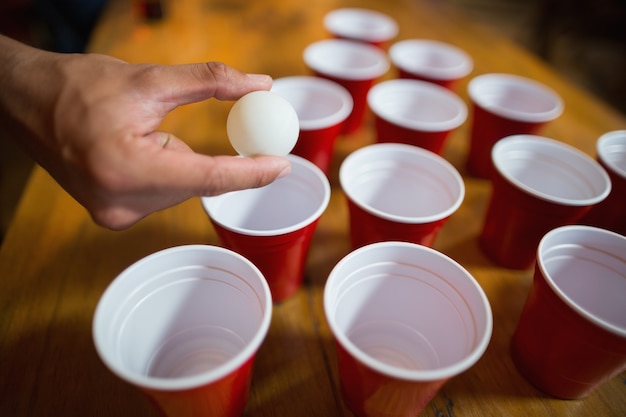 Mano de hombre jugando beer pong