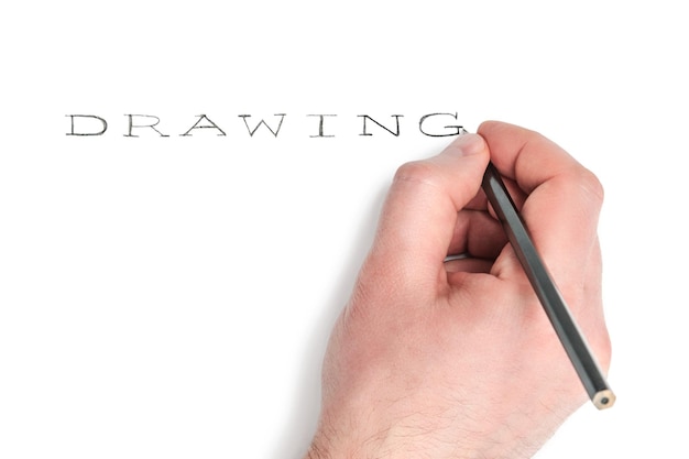 Mano de hombre con un lápiz escribe la palabra dibujo aislado sobre fondo blanco.