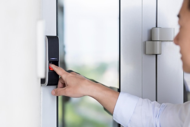 La mano de un hombre de negocios asiático usando un sensor de huellas dactilares cerradura de la puerta timbre moderno con cámara de video