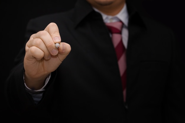 La mano del hombre de negocios escribe en la pantalla sobre fondo negro