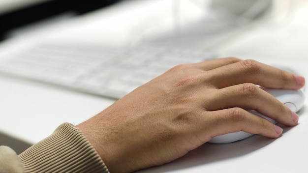 mano de hombre de negocios escribiendo en el teclado del ordenador portátil con el mouse