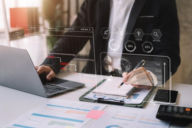 Mano de hombre de negocios Gerente de proyecto trabajando y actualizando tareas y diagrama de Gantt programando diagrama virtual con tableta de teléfono inteligente y computadora portátil en la oficina