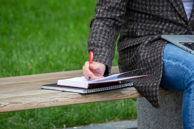 Mano de hombre de negocios con pluma y planificación de trabajo de bloc de notas