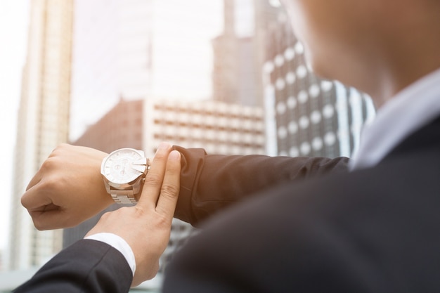 Mano de hombre de negocios de primer plano, llegar tarde a trabajar