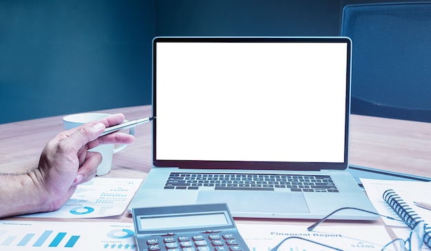 Foto mano de hombre de negocios sosteniendo un bolígrafo para simular la presentación de presentación de diapositivas de resumen de ventas en una computadora portátil de pantalla con calculadora, gafas y papeleo en la mesa en la sala de reuniones