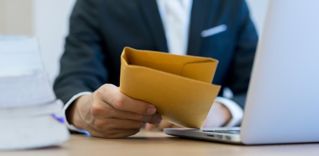 Mano de hombre de negocios sosteniendo y enviar secreto sobre bronceado