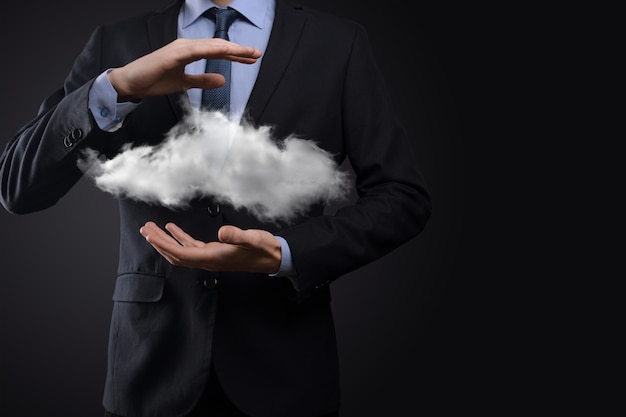 Mano de hombre de negocios sosteniendo la nube. Concepto de computación en la nube, cerca del joven hombre de negocios con la nube sobre su mano. El concepto de servicio en la nube.