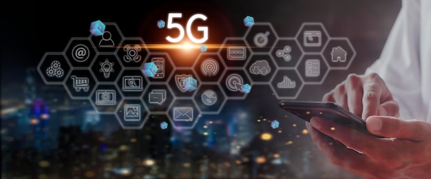 La mano del hombre de negocios sostiene la red de conexión del teléfono móvil 5G con los sistemas inalámbricos de red de tecnología de concepto de icono e Internet de las cosas nuevas tecnologías que se avecinan en el futuro Conexión de red 5G