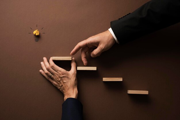 Mano de un hombre de negocios subiendo las escaleras con los dedos apoyado por su colega