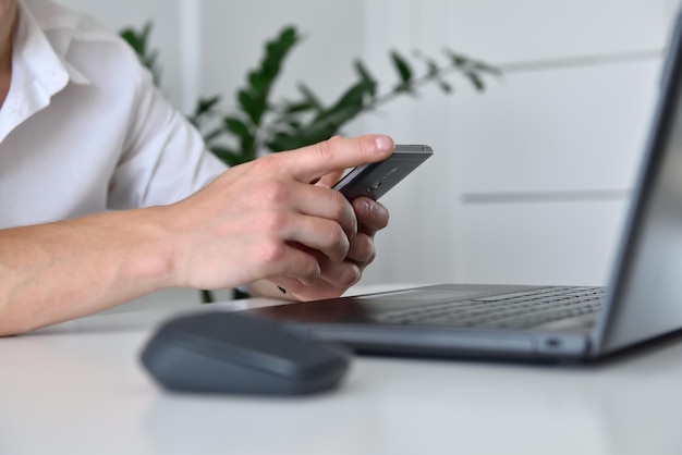 Mano de hombre de negocios con teléfono móvil mirando el plan de negocios