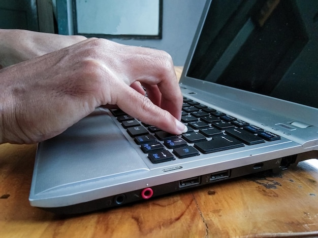 Foto mano de hombre de negocios trabajando con laptop en mesa de madera