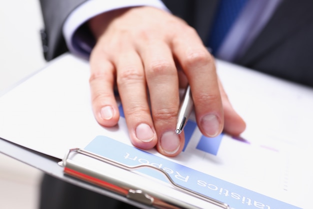 Mano de hombre de negocios en traje de relleno y firma